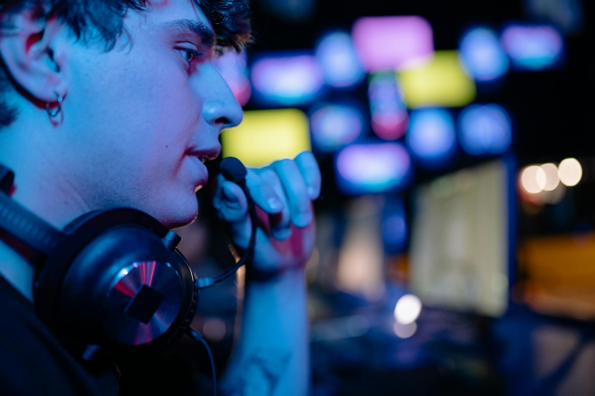 Side profile of a gamer engaged with a headset during intense gaming session.
